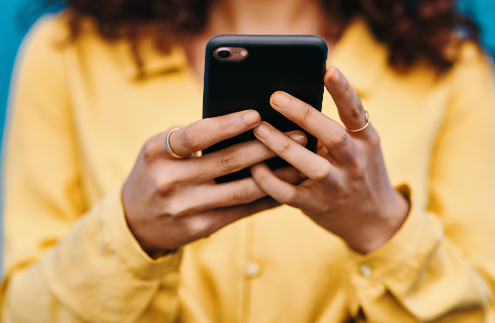 close-up of a woman's hands typing on a smartphone